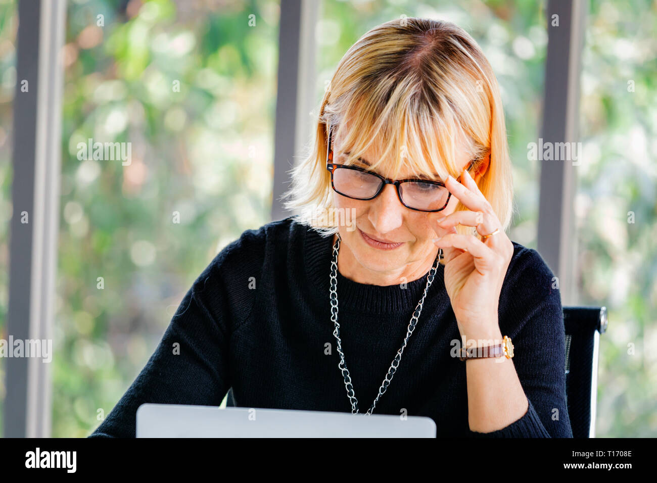 40 young businesswoman se concentrer et à regarder dans l'ordinateur portable ordinateur bureau Banque D'Images