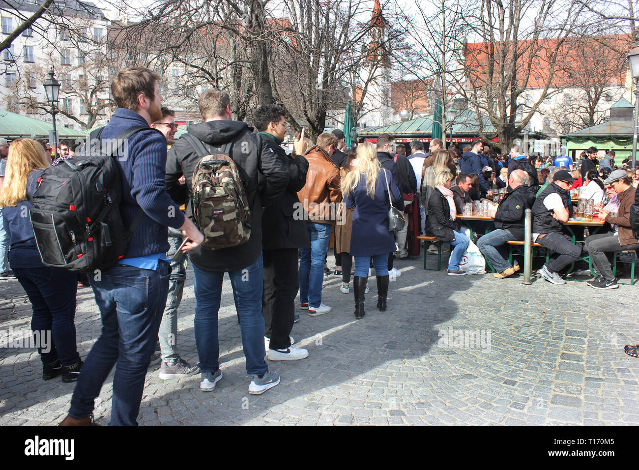 Les gens faisant la queue pour obtenir gratuitement de la bière dans le jardin de la bière, Munich, Viktualienmarkt. Offre spéciale en raison de 125 Jubilé anniversaire de la brasserie. Banque D'Images