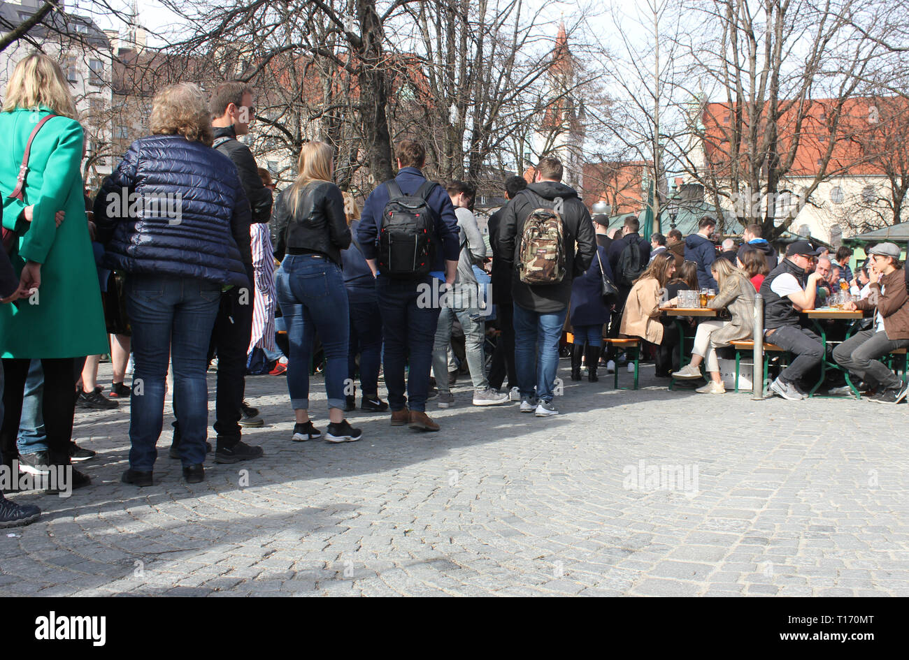 Les gens faisant la queue à l'extérieur pour une bière gratuite dans le jardin de la bière, Munich, Viktualienmarkt. Offre spéciale en raison de 125 Jubilé anniversaire de la brasserie. Banque D'Images