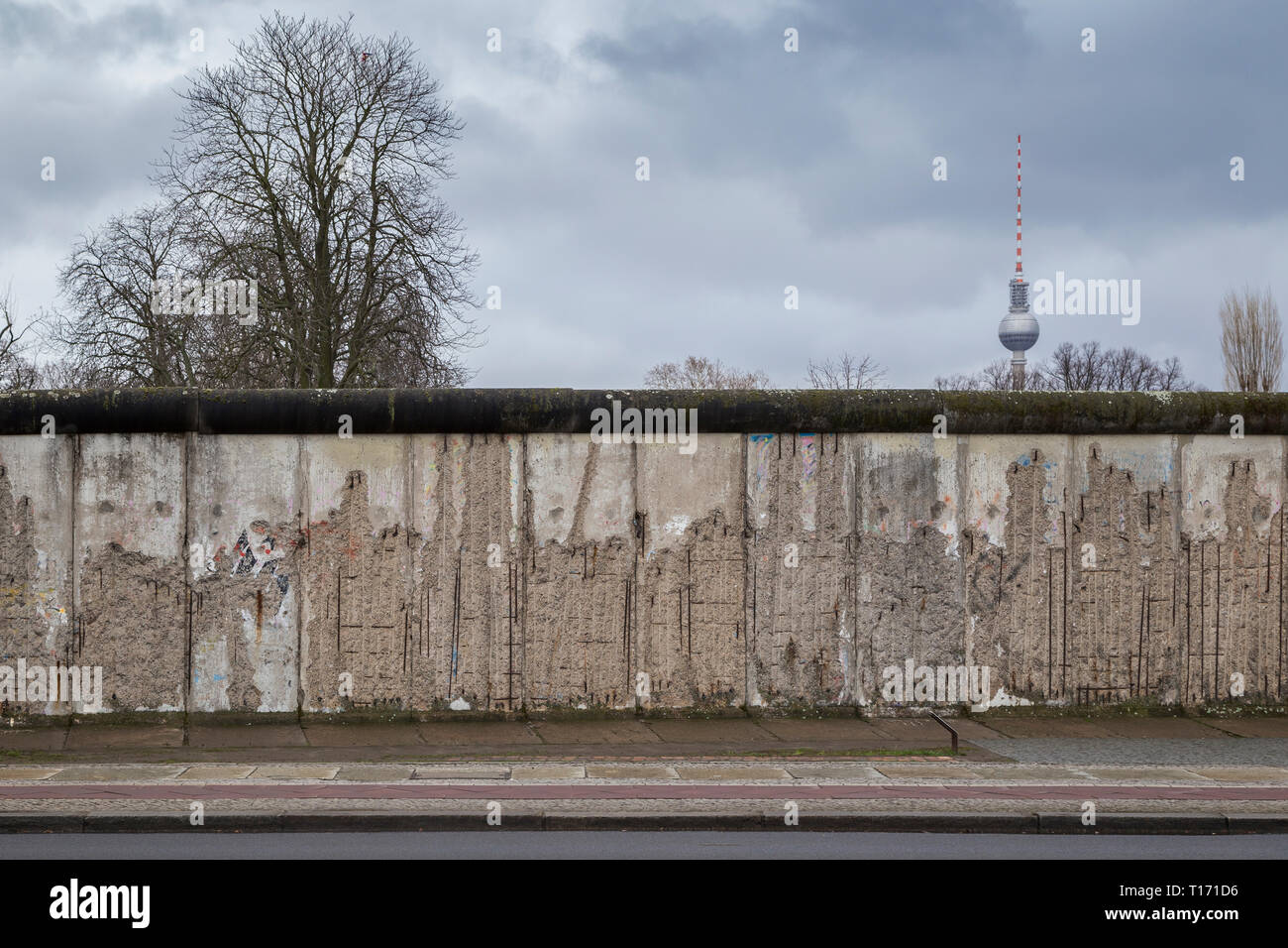 Vue de face d'une section de l'original au mur de Berlin, le Mémorial du Mur de Berlin (Berliner Mauer) à Berlin. Fernsehturm, la tour de télévision est à l'arrière-plan. Banque D'Images