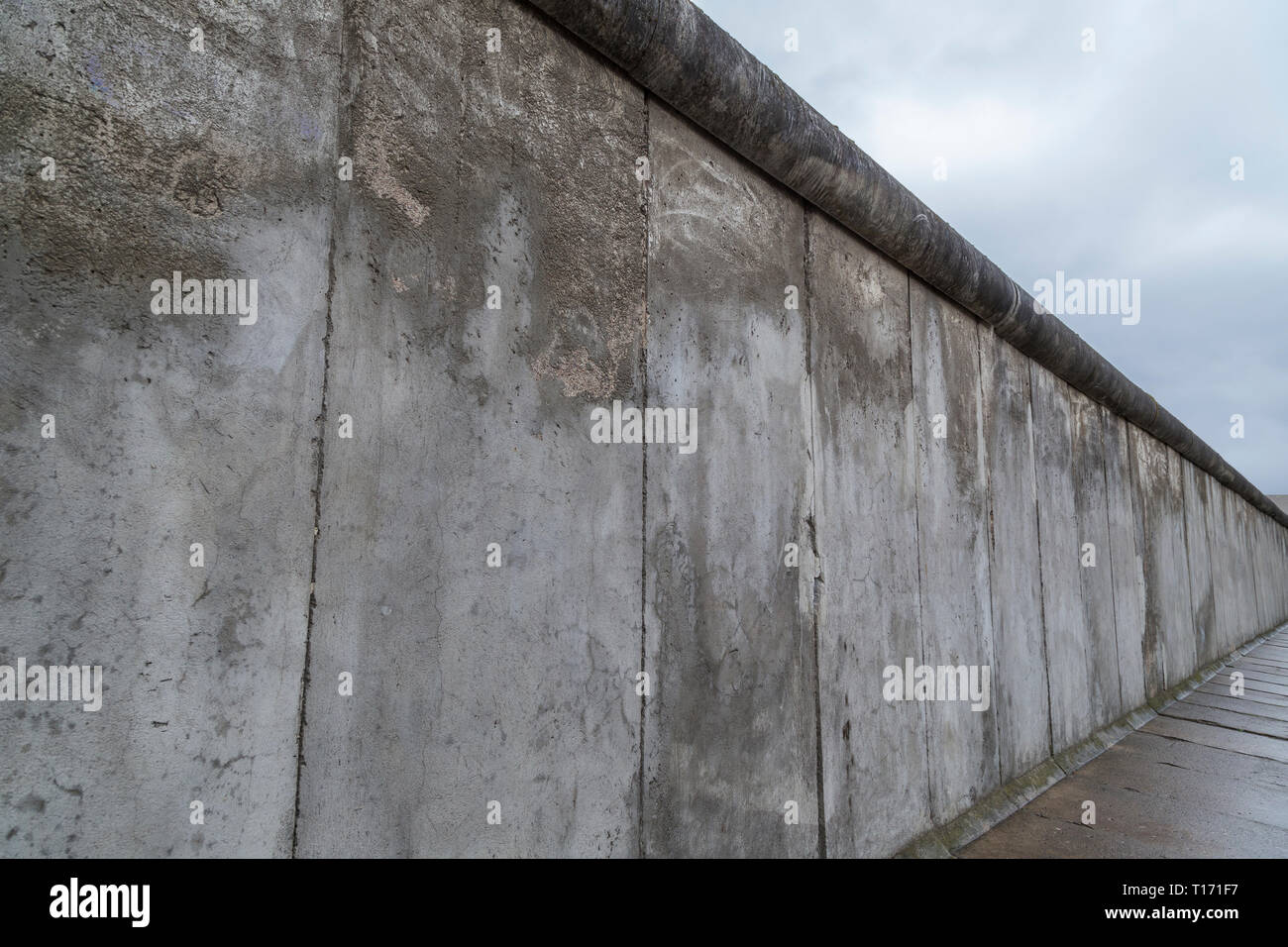 Vue latérale d'une section de l'original au mur de Berlin, le Mémorial du Mur de Berlin (Berliner Mauer) à Berlin, Allemagne, un jour nuageux. Banque D'Images