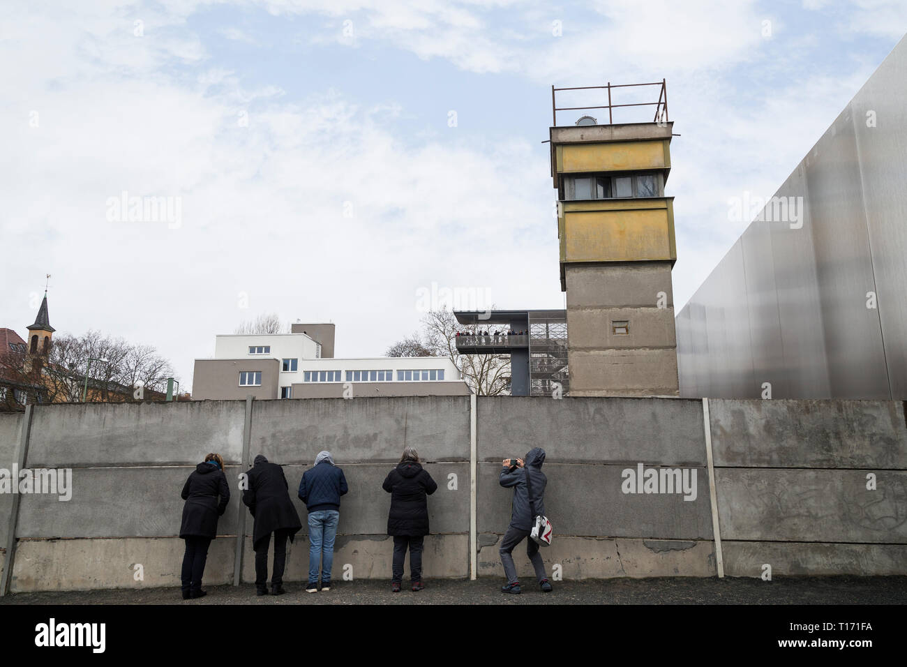 Les personnes au Mémorial du Mur de Berlin (Berliner Mauer) à Berlin, Allemagne. Tour de guet est derrière le mur de Berlin. Centre de documentation est dans le backgroun Banque D'Images