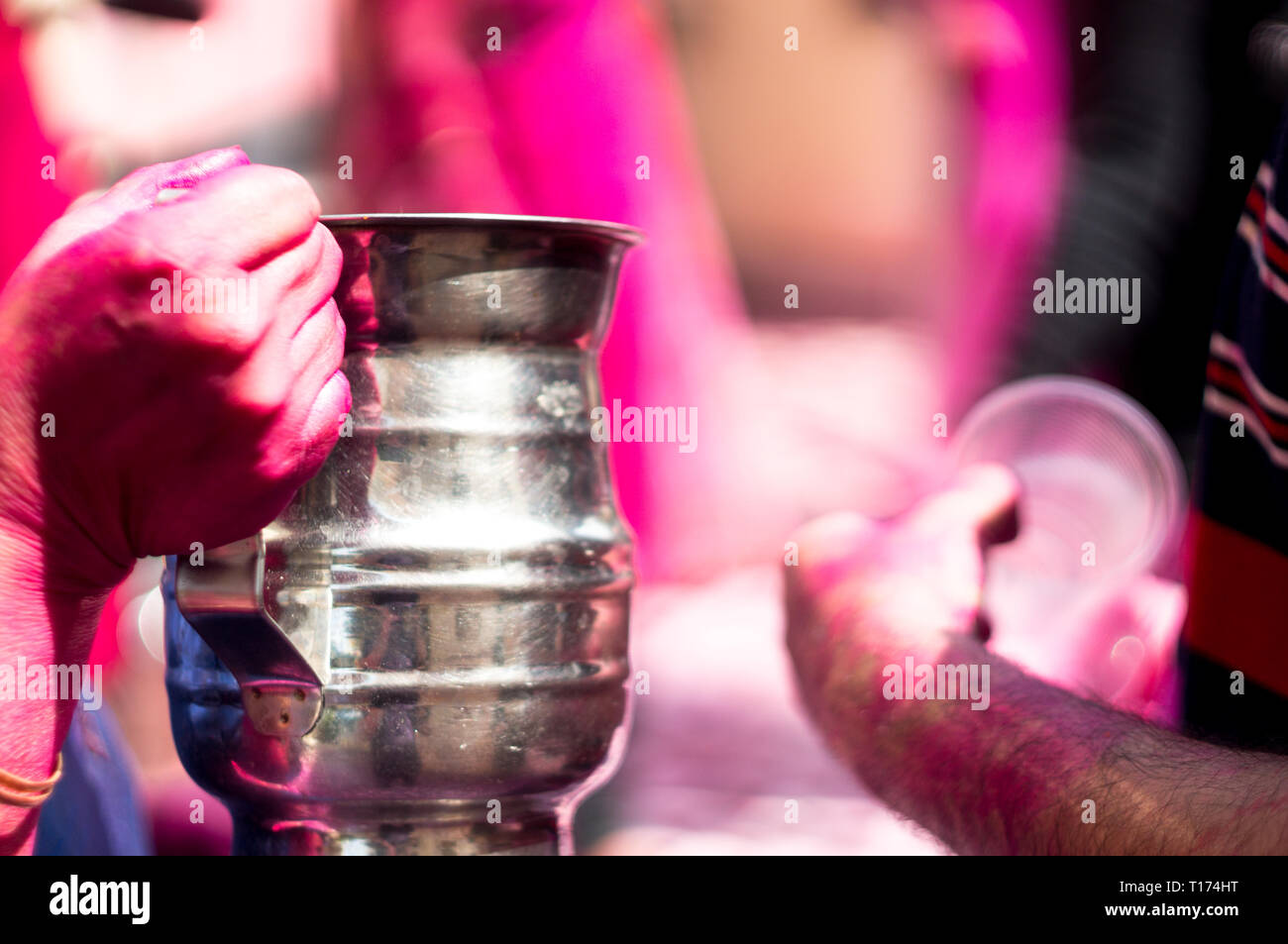 Colorful hands holding tasses jetables de thandai sur holi festival hindou Banque D'Images