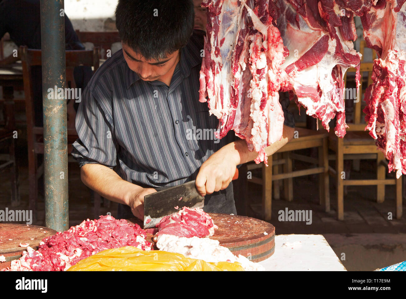 Une boucherie ouïghoure travaillant sur le marché du bétail du dimanche, juste à l'extérieur de Kashgar, dans la région autonome du Xinjiang, en Chine. Banque D'Images