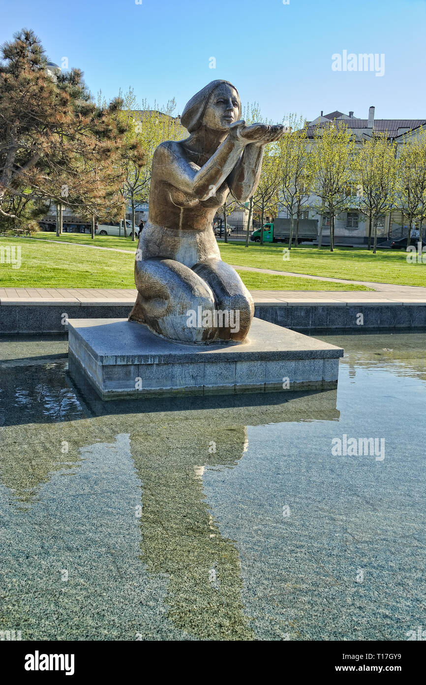 Fontaine Monument 'accorder à l'eau' = Sculpture d'une femme assise sur ses  genoux avec les bras tendus sur le côté de la baie de Novorossiysk avec  refle Photo Stock - Alamy