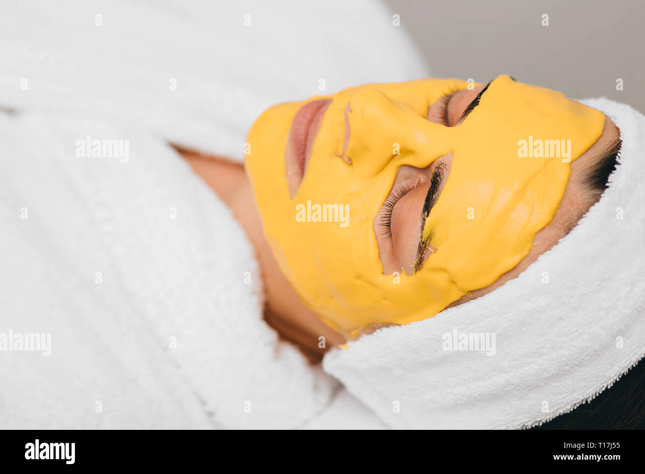 Femme avec masque de beauté avec l'extrait d'orange sur le visage. Traitement de la peau à l'aide de masque de beauté Banque D'Images