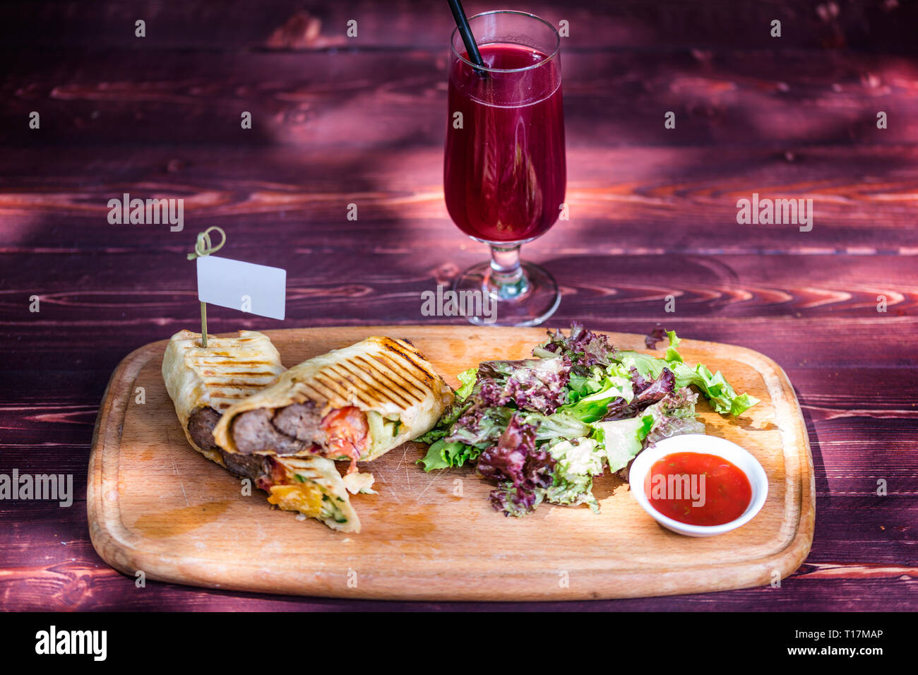 Sandwich shawarma sains à base de boeuf, salade verte, sauce et de la limonade. À la fine planche de bois, et fond de bois. Banque D'Images