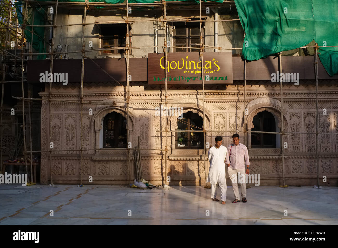 Deux visiteurs dans le parc de Sri Sri Radha Gopinath Temple et Govinda's Vegetarian Restaurant, à Mumbai, en Inde, dans une conversation profonde Banque D'Images