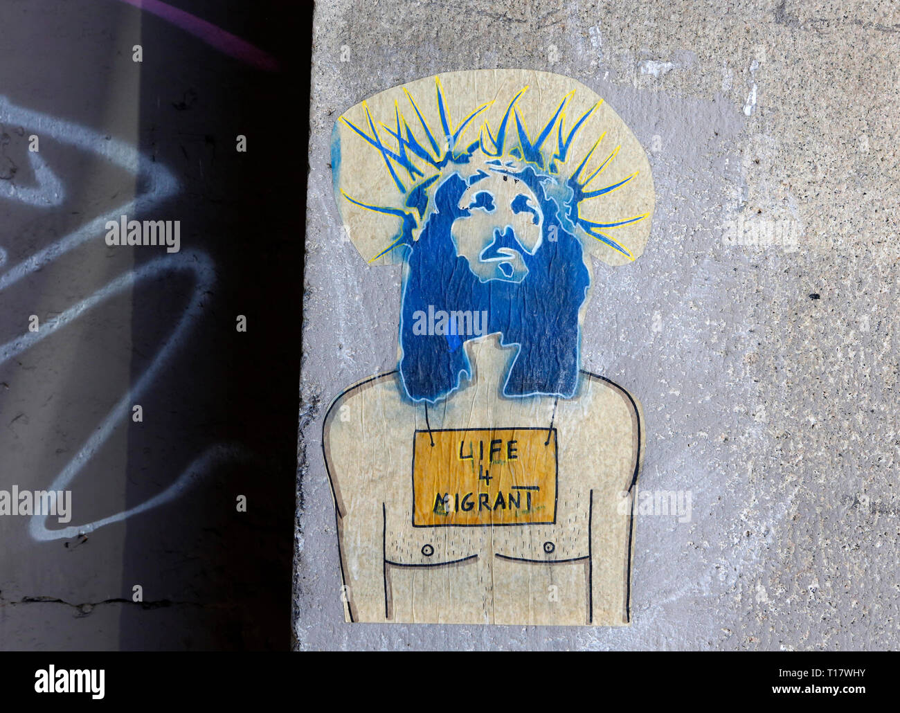 Une peinture murale représentant Jésus avec une couronne d'épines sur sa tête et un signe à lire 'La Vie 4 Migrants' sur sa poitrine, est vu sur un mur à Rome, Italie. Banque D'Images