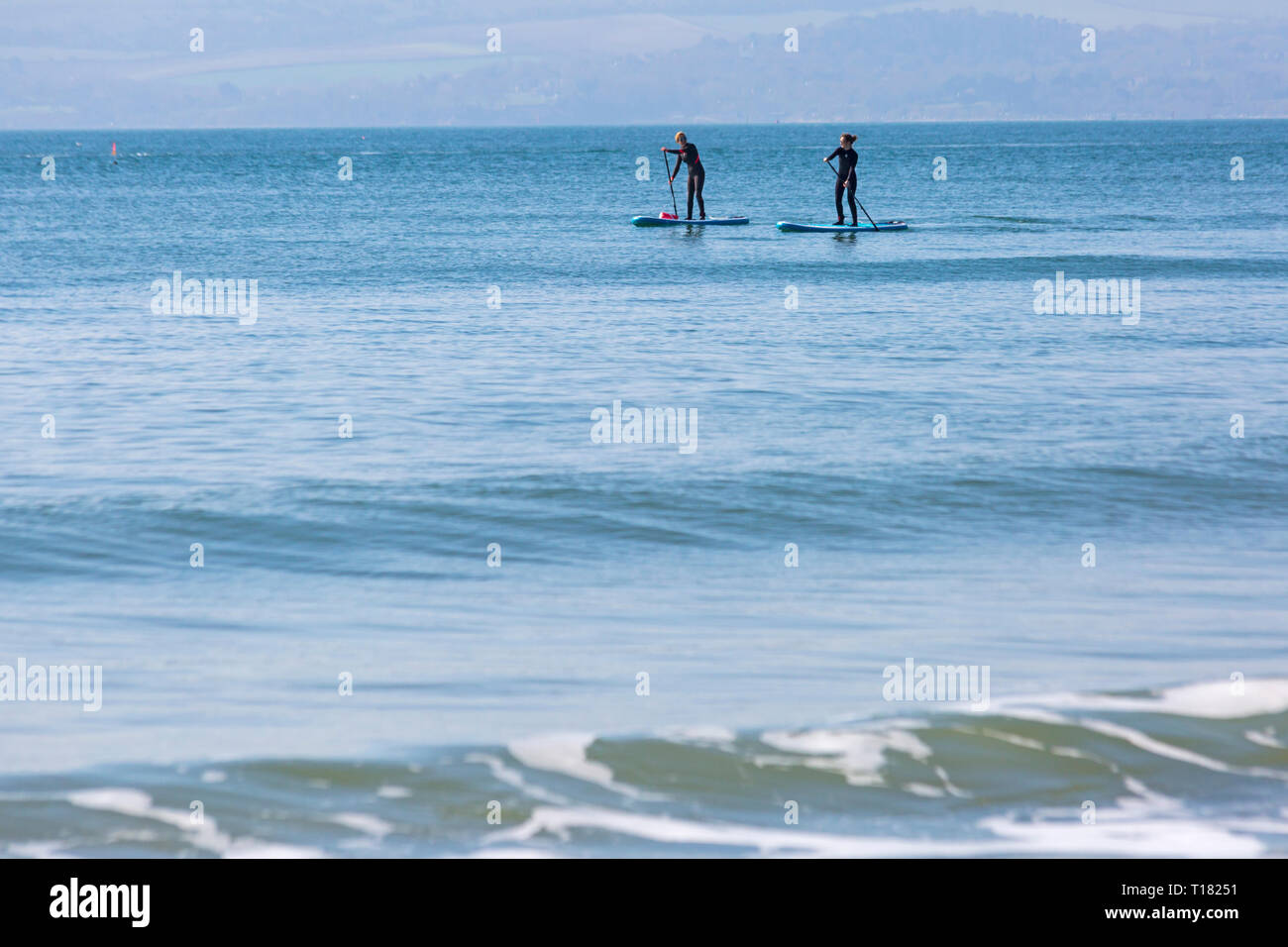 Bournemouth, Dorset, Royaume-Uni.24 mars 2019.Météo au Royaume-Uni : belle journée ensoleillée avec un ciel bleu et un soleil chaud sur les plages de Bournemouth, tandis que les visiteurs se rendent au bord de la mer pour profiter au maximum du temps glorieux.Levez les paddle-boarders sur la mer.Crédit : Carolyn Jenkins/Alay Live News Banque D'Images