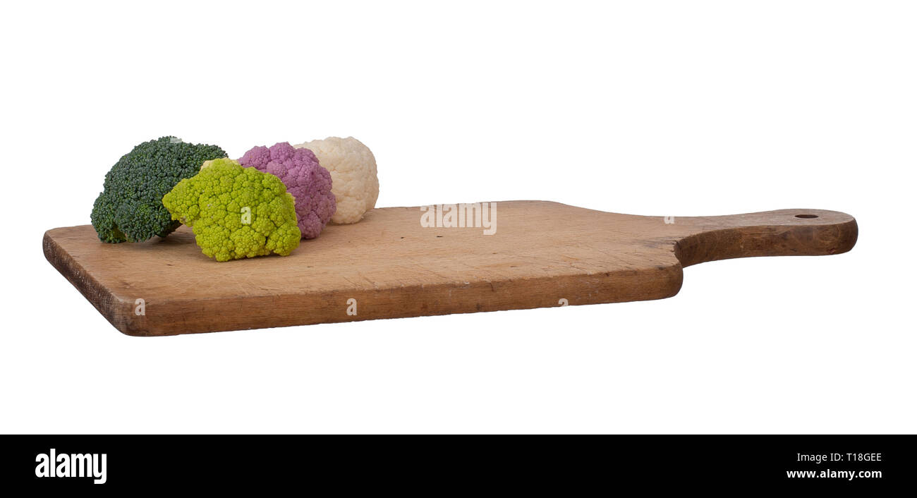 Légumes colorés sur la planche à découper en bois isolé sur blanc. Chou-fleur cru, violet, blanc et vert, avec des brocolis. Assortiment en bonne santé. Banque D'Images
