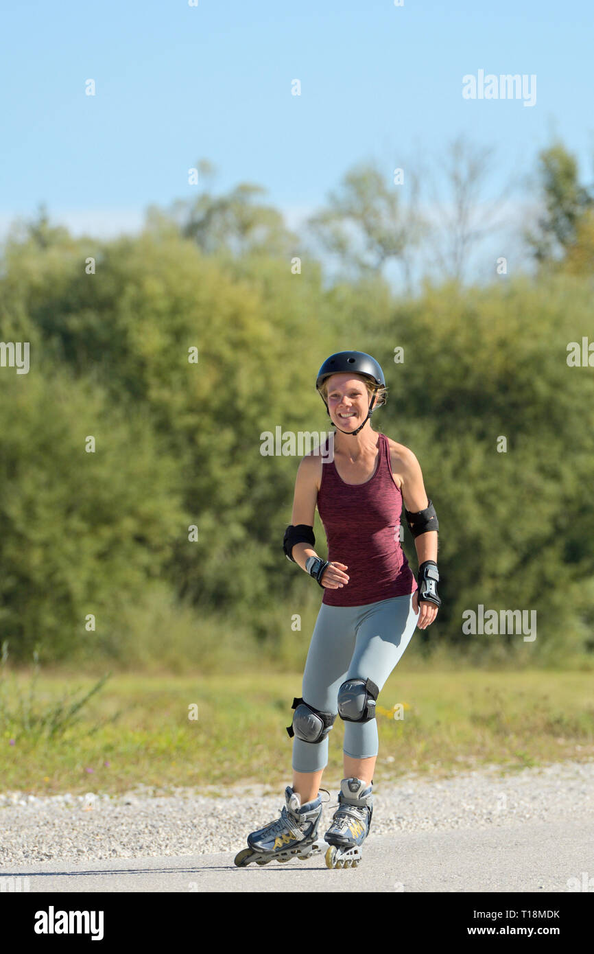 Jeune femme patin à roues alignées, à la fin de l'été Banque D'Images