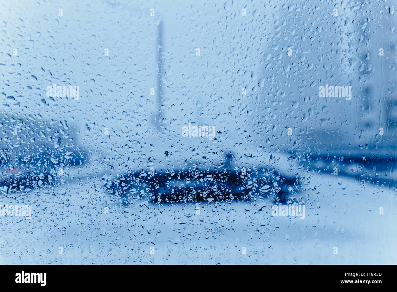 Résumé de la circulation en hiver. Vu de la circulation à l'intérieur d'une voiture. Gouttes d'eau sur le pare-brise et des feux arrière de voiture en bokeh Banque D'Images