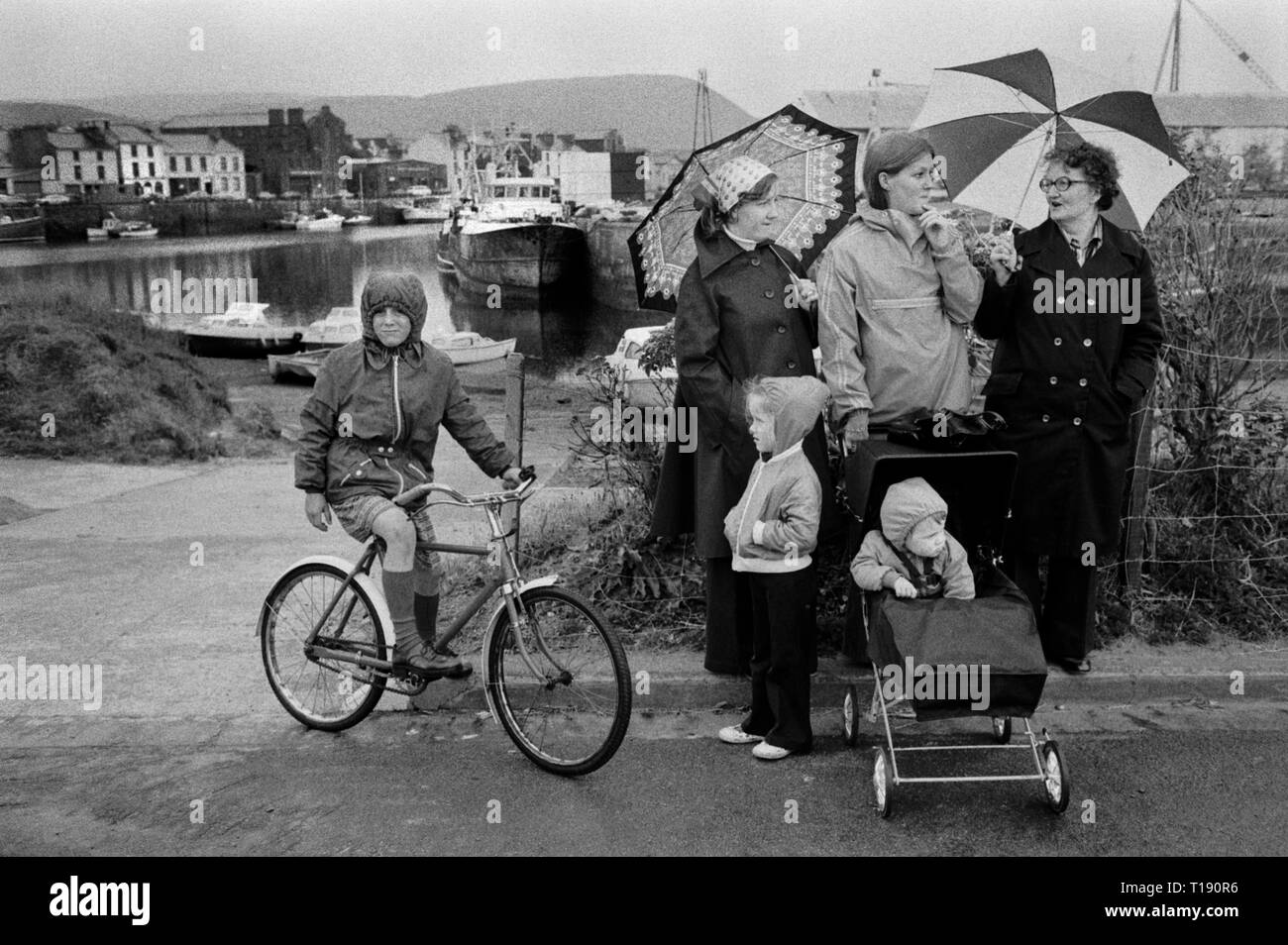 Île de Man, port de Peel et famille avec des enfants qui attendent sous la pluie. 1970s. 1978 HOMER SYKES Banque D'Images