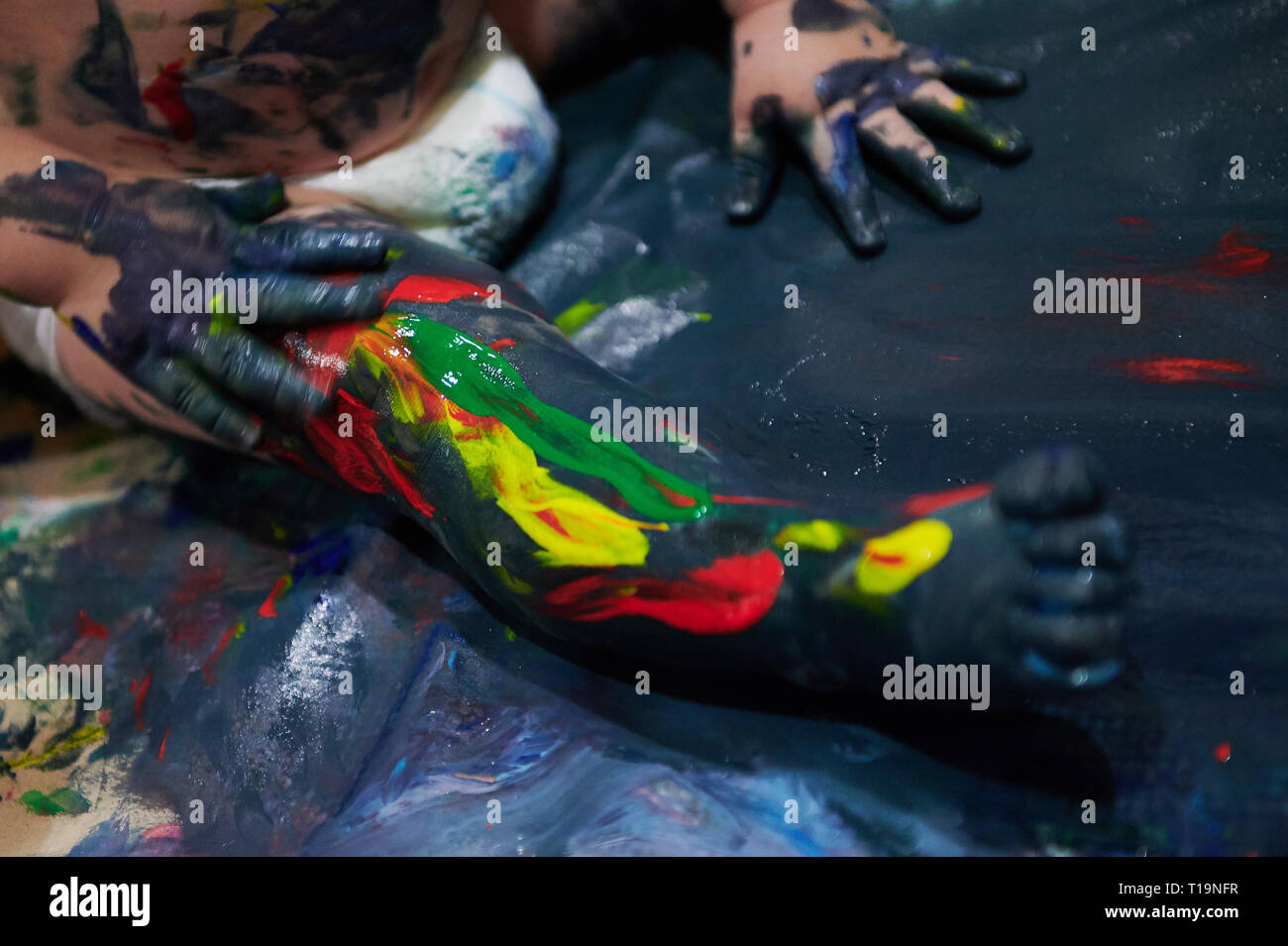 Peinture colorée sur la jambe pour enfants vue en gros plan. Dirty baby leg Banque D'Images