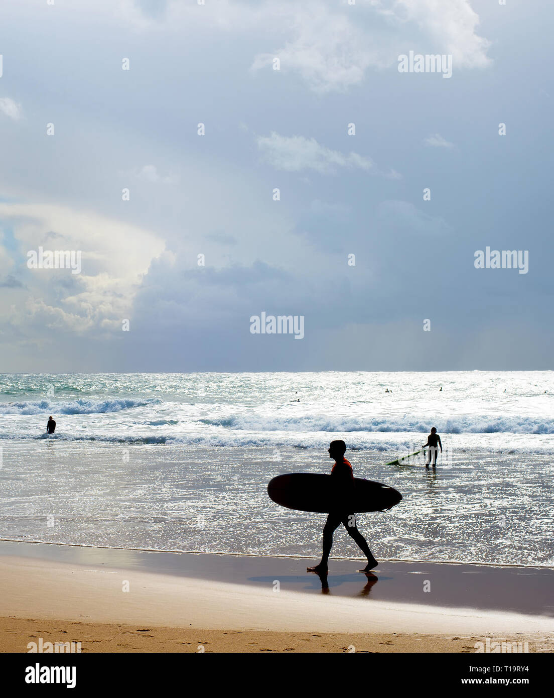 Surfer avec une planche de surf sur la plage, silhouette. Algarve, Portugal Banque D'Images