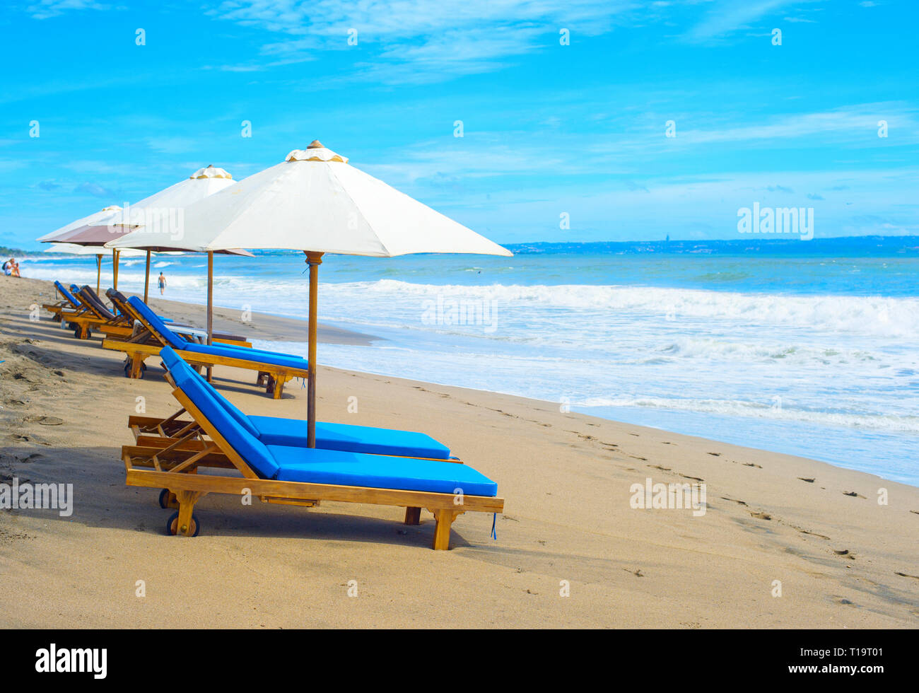 Chaises longues sous les parasols sur la plage de sable de tropical resort, l'île de Bali, Indonésie Banque D'Images