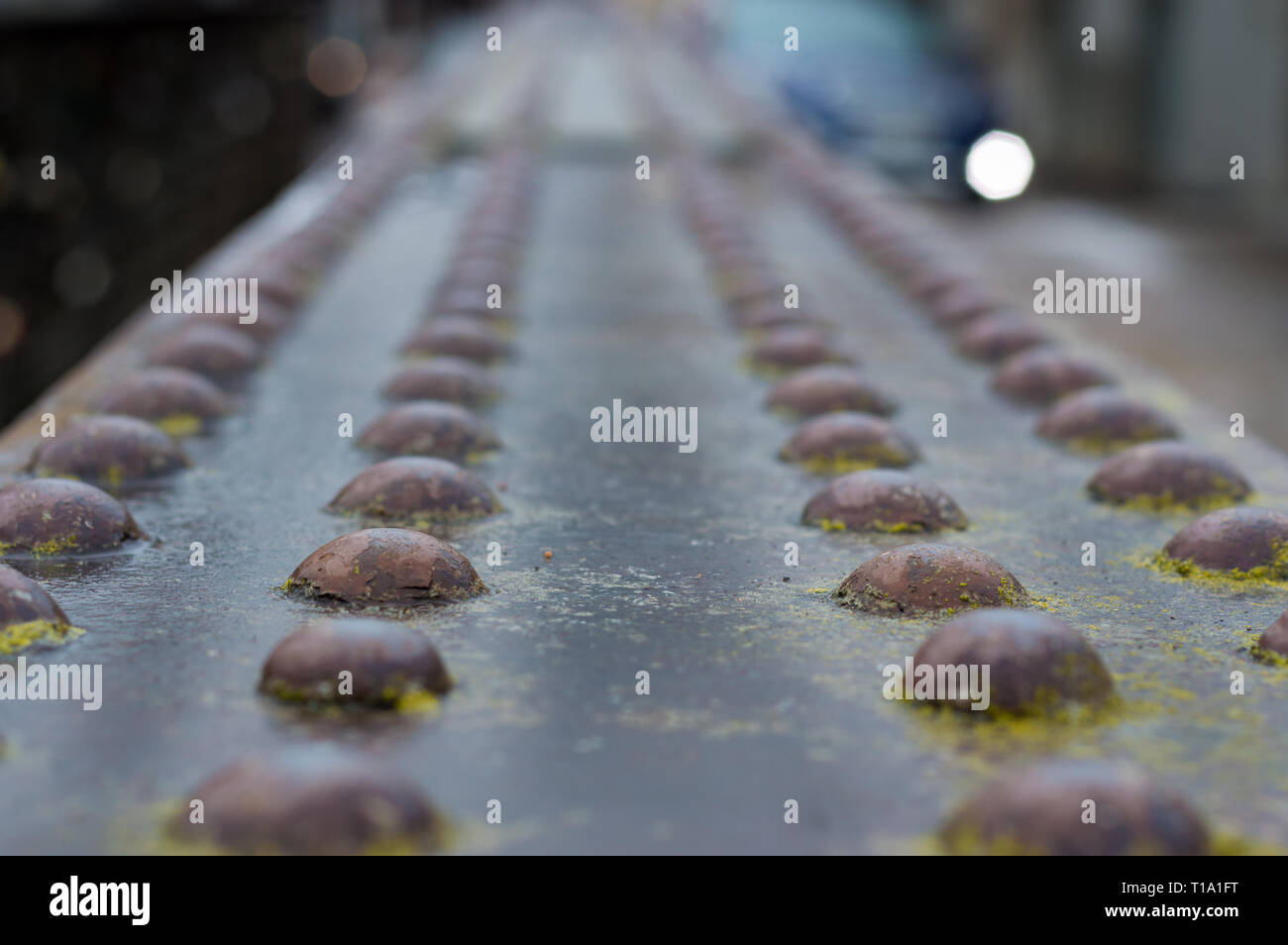 Un garde-corps en métal rouillé d'un pont avec une multitude de vis sur haut de c Banque D'Images