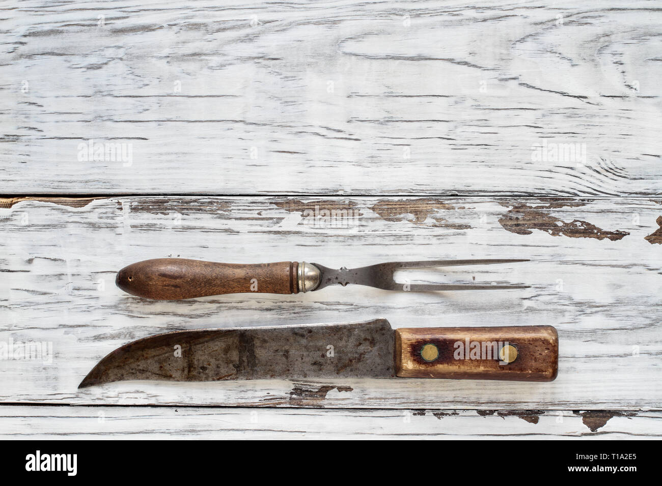 Fourchette à viande vintage et Butcher's knife par-dessus une table rustique en bois / arrière-plan. Droit tourné à partir de la vue de dessus. Banque D'Images
