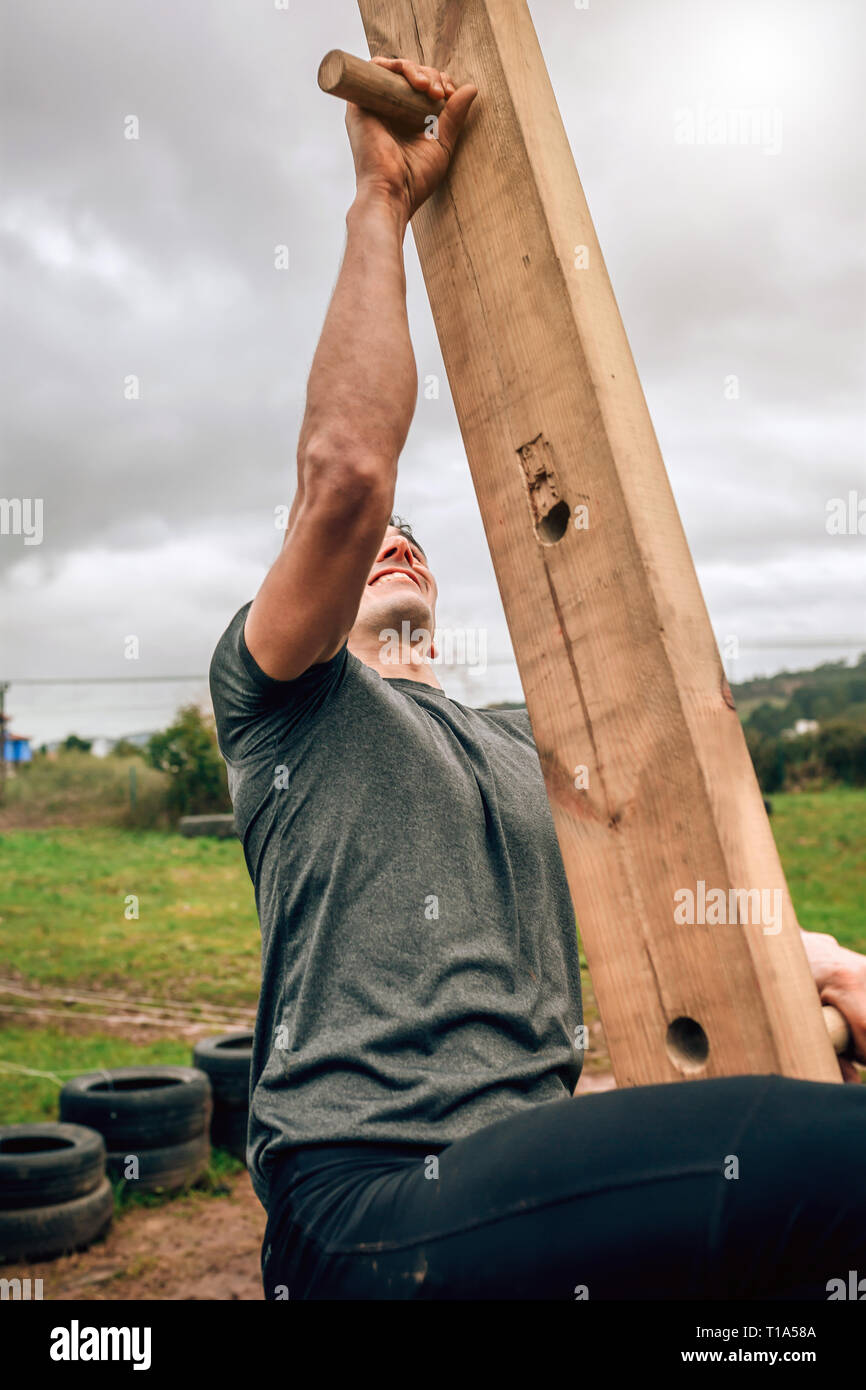 Participant à une course à obstacles faisant pegboard Banque D'Images