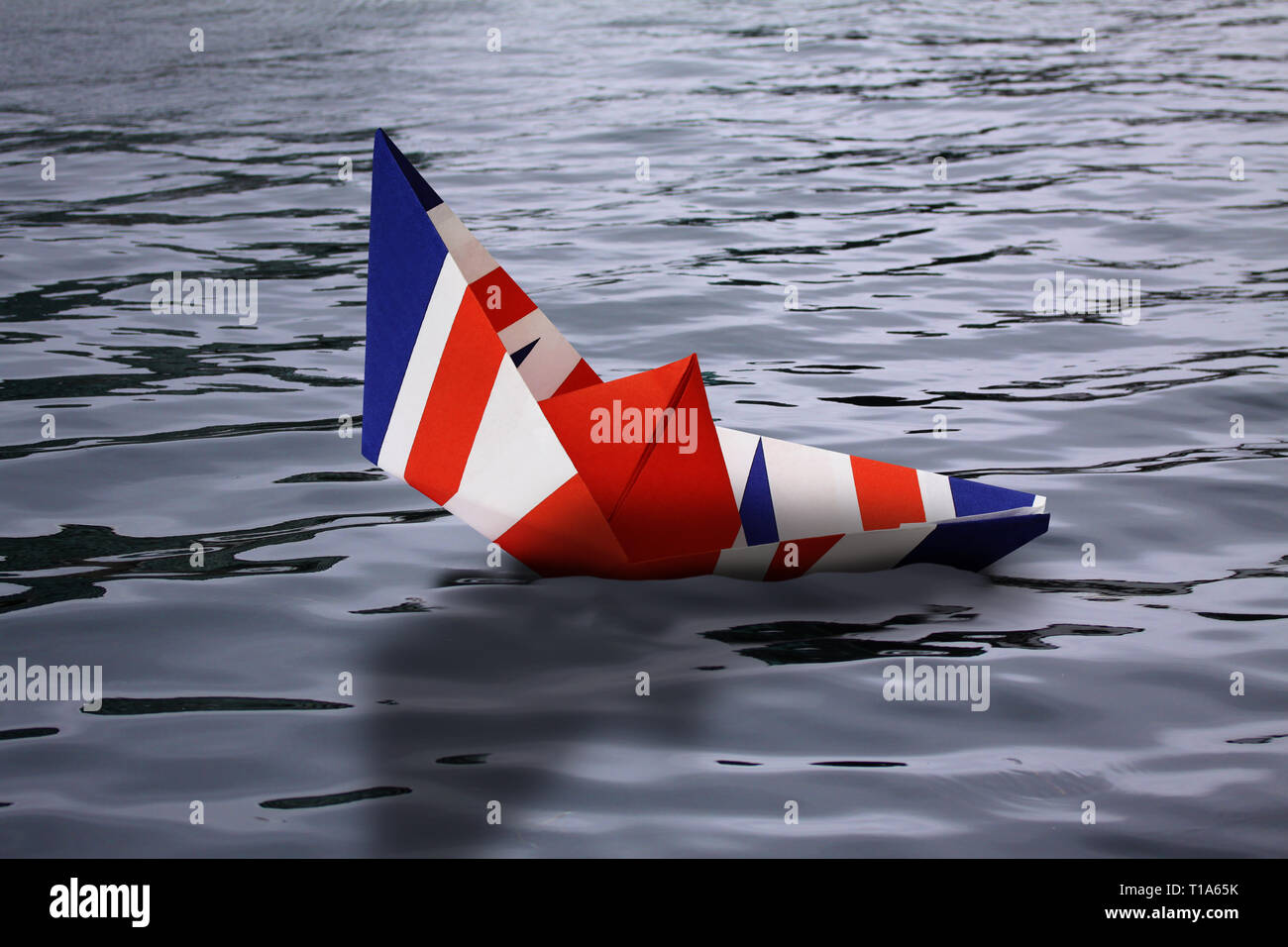 Bateau de papier comme le drapeau britannique fait naufrage dans l'eau - concept montrant l'Angleterre de quitter l'Union européenne et l'économie vers le bas et Royaume-Uni - Noyade pho Banque D'Images