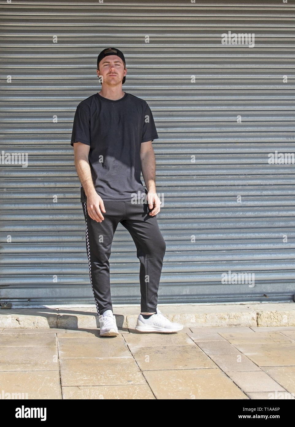 Les jeunes sportifs occasionnels avec l'homme habillé en noir sur l'arrière de la tôle ondulée style Wall Street Banque D'Images