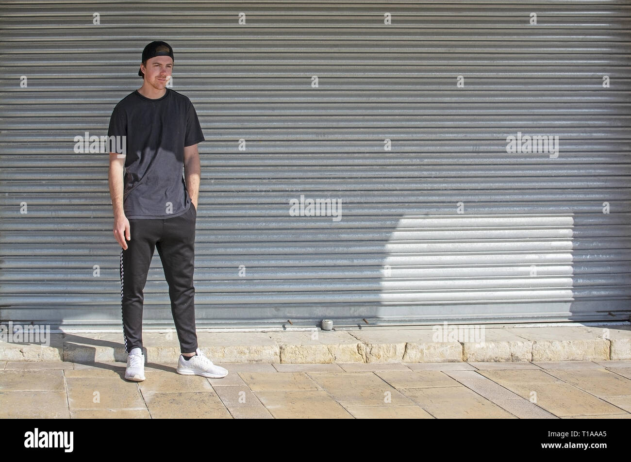 Les jeunes sportifs occasionnels avec l'homme habillé en noir sur l'arrière de la tôle ondulée style Wall Street Banque D'Images