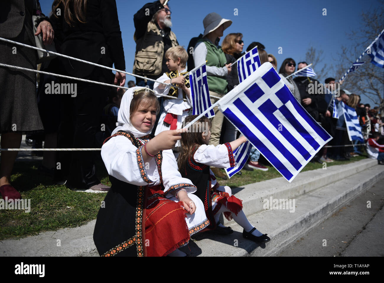Thessalonique, Grèce. Mar 25, 2019. Les enfants vêtus de costumes traditionnels tenir des drapeaux grecs comme ils regarder un défilé. La fête nationale du 25 mars marque le début de la révolution grecque de retour en 1821, qui a abouti à l'indépendance contre les 400 ans de domination ottomane. Pendant le défilé des centaines de personnes ont protesté contre l'accord de Prespa criant des slogans tels que ''Macédoine n'est qu'un, et c'est le Grec''. Prespa est un accord conclu le 12 juin 2018 entre la Grèce et la Macédoine du Nord, sous l'égide des Nations Unies, la résolution d'un différend de longue date sur le NAM Banque D'Images