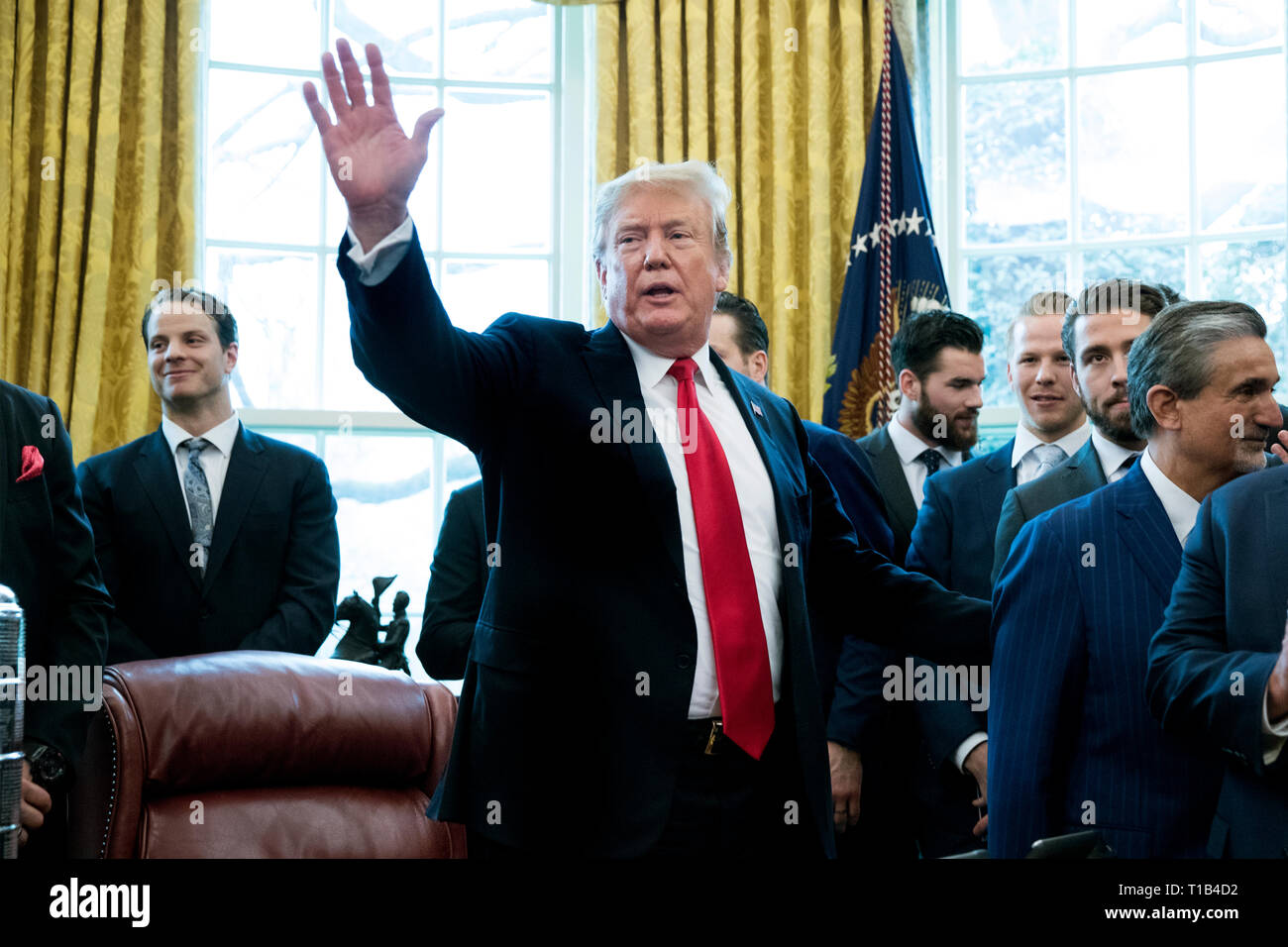 Washington, DC, USA. Mar 25, 2019. Le président américain, Donald J. Trump (C) vagues à l'issue d'une séance de photos avec les joueurs et le personnel de la Ligue nationale de hockey (LNH) 2018 Champions de la Coupe Stanley, les Capitals de Washington, dans le bureau ovale de la Maison Blanche à Washington, DC, USA, 25 mars 2019. Crédit : Michael Reynolds/Piscine via CNP | Conditions de crédit dans le monde entier : dpa/Alamy Live News Banque D'Images
