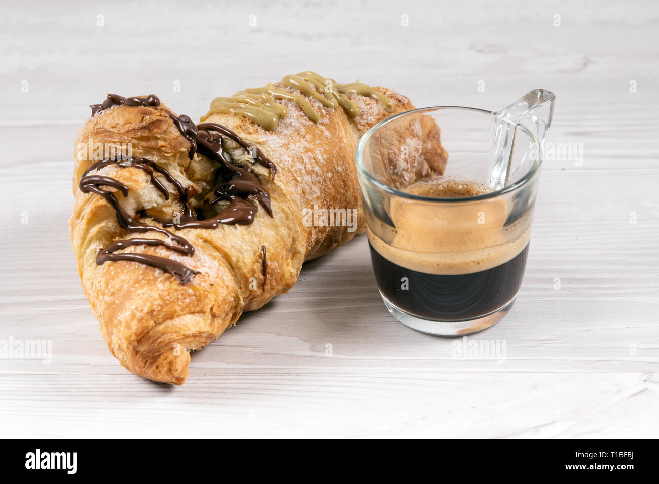 Brioche gourmande avec du chocolat et farci à la pistache sur une table en bois Banque D'Images