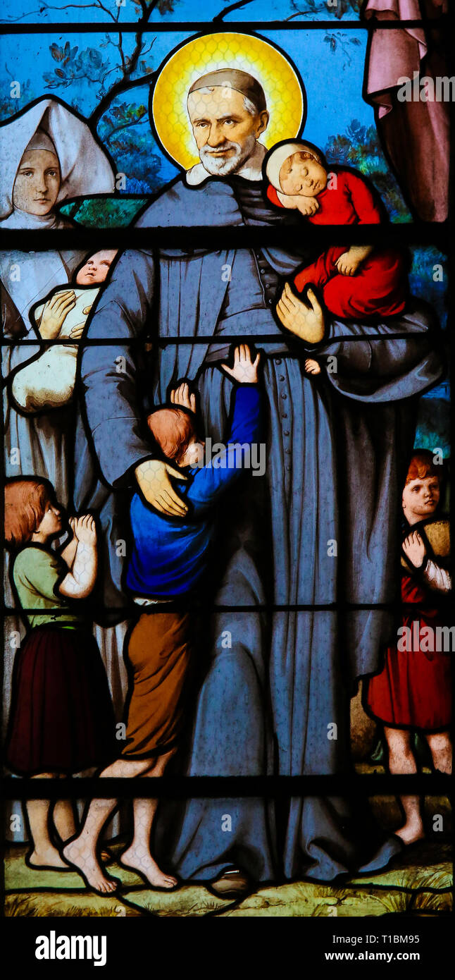 Vitraux dans l'église de Saint Severin, Quartier Latin, Paris, France, représentant Saint Vincent de Paul et les enfants. Banque D'Images