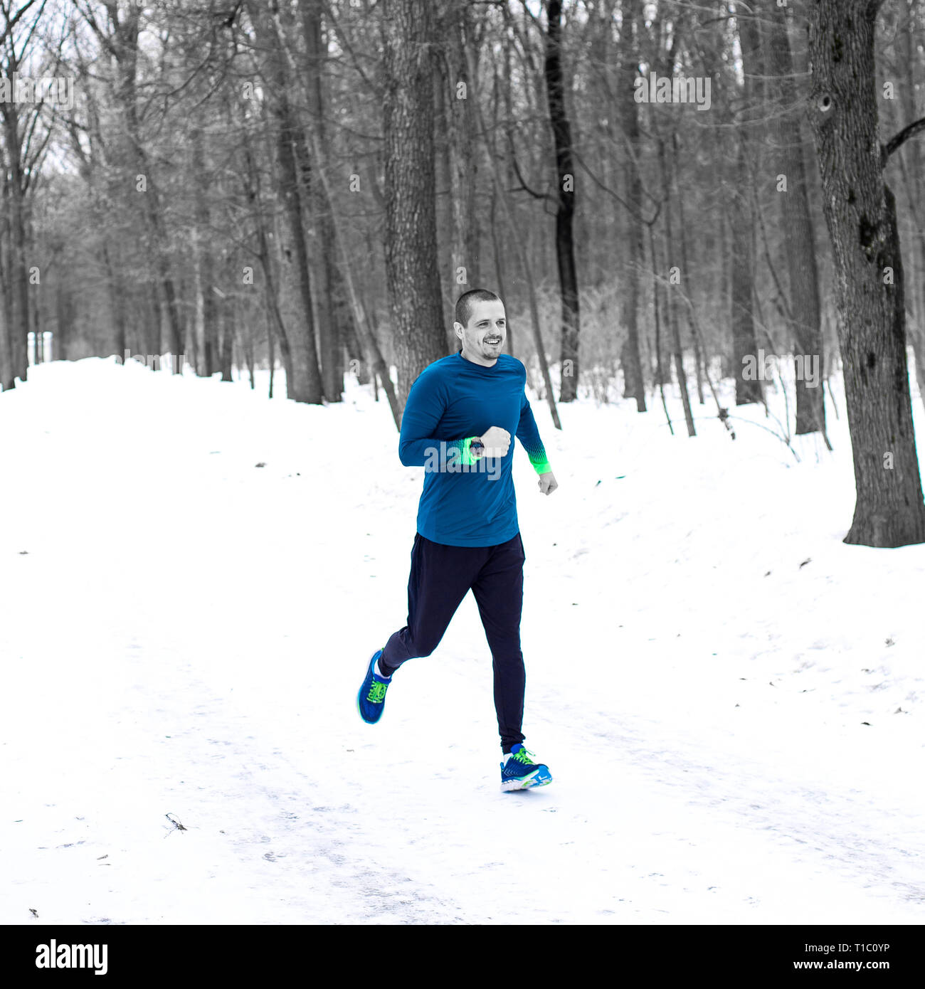 Homme adulte runner courir dans la forêt en hiver Banque D'Images