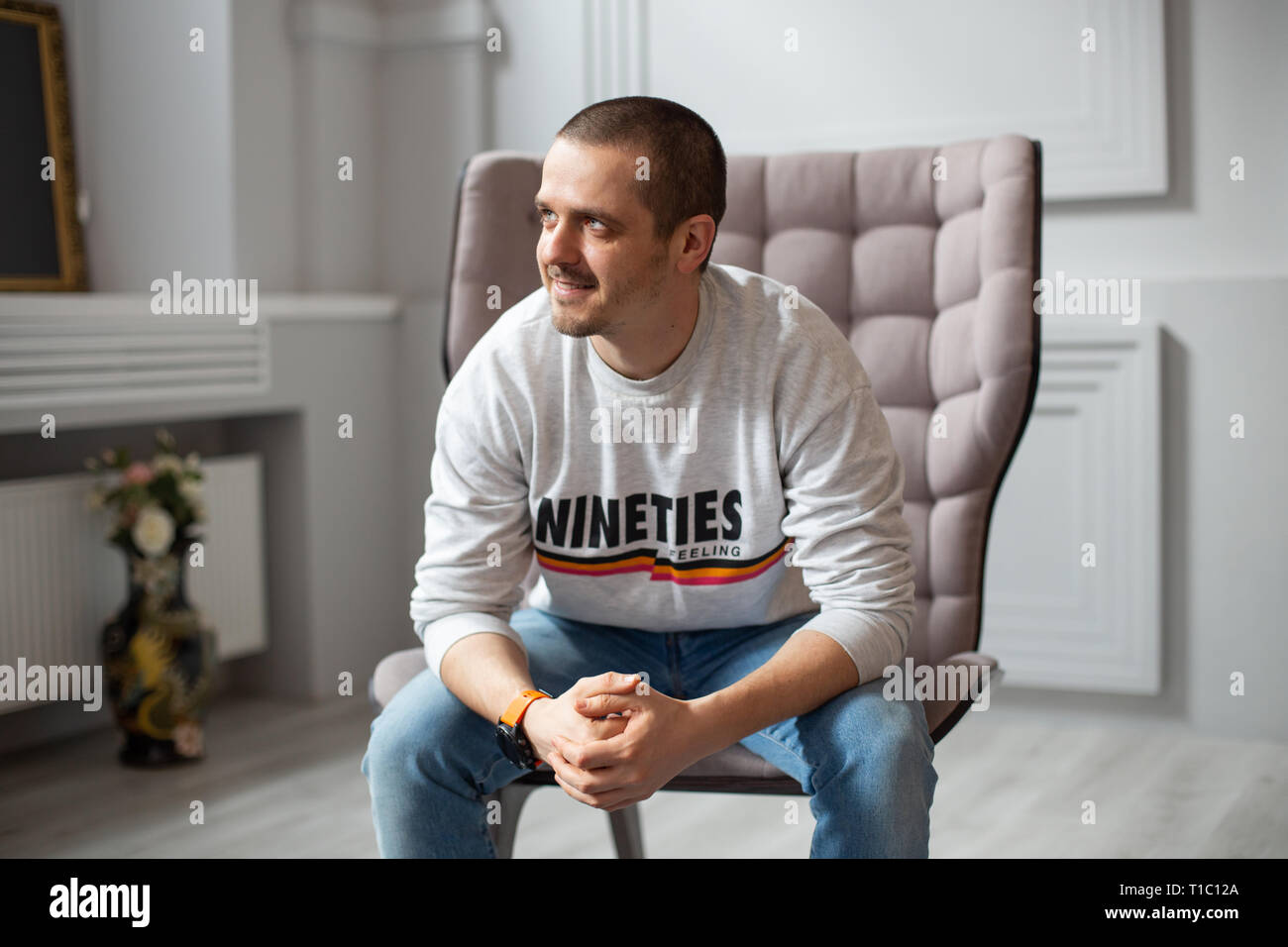L'homme assis sur une chaise et à la recherche sur le côté Banque D'Images