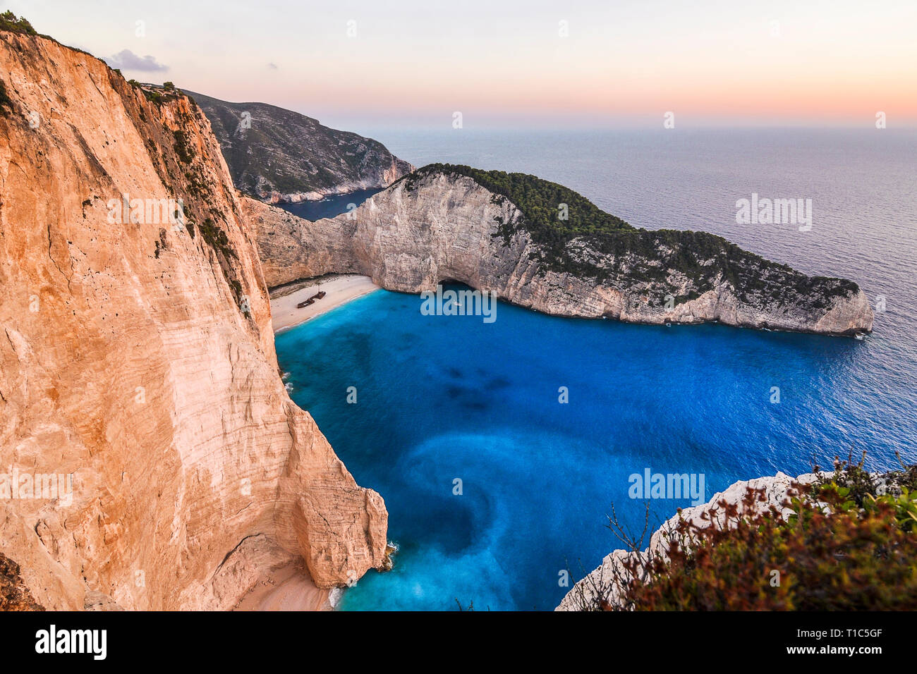 Paysage célèbre de la plus belle plage de Navagio - sur l'île de Zakynthos en Grèce. Coucher du Soleil vue depuis le bord de la falaise sur la mer bleue et pittoresque se Banque D'Images