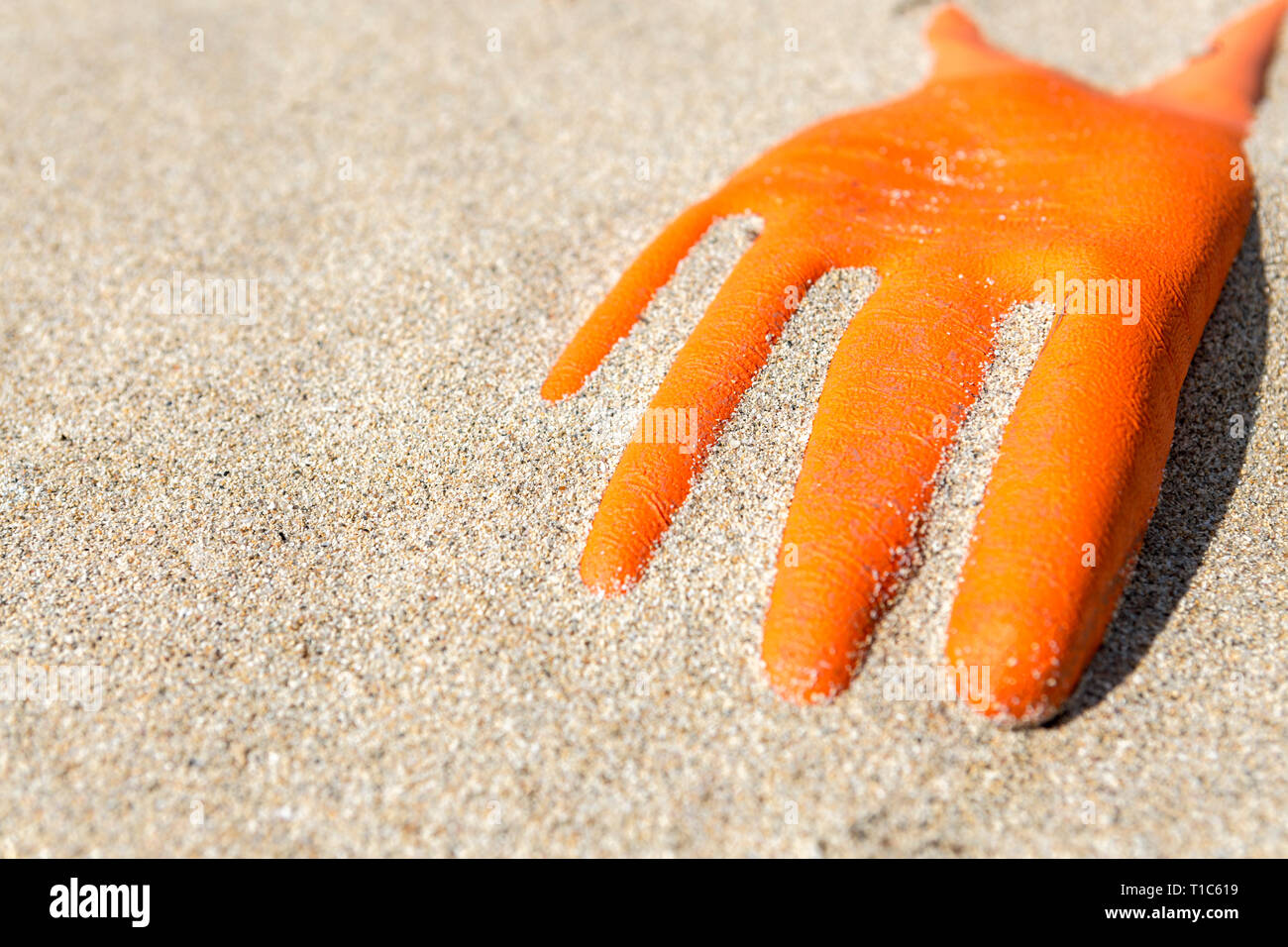 Gant en caoutchouc orange échoués sur la côte écossaise, Isle Of Lewis, îles Hébrides, Ecosse, Royaume-Uni Banque D'Images