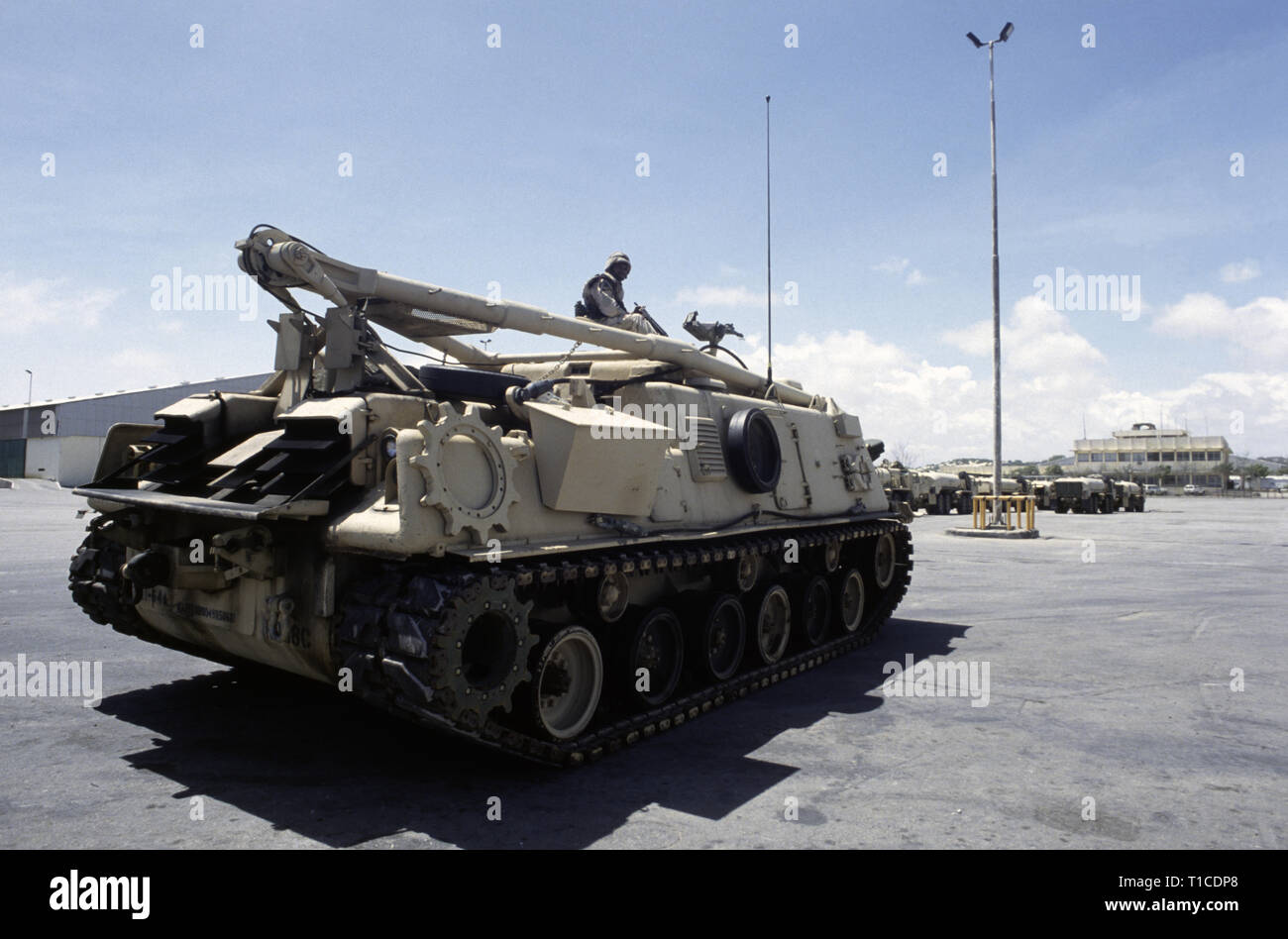 29 octobre 1993 un soldat de l'armée américaine de la 24e Division d'infanterie, 1e Bataillon du 64e régiment blindé, est situé au-dessus de son véhicule de M88, dans le port de Mogadiscio, en Somalie où il vient d'arriver par la mer. Banque D'Images