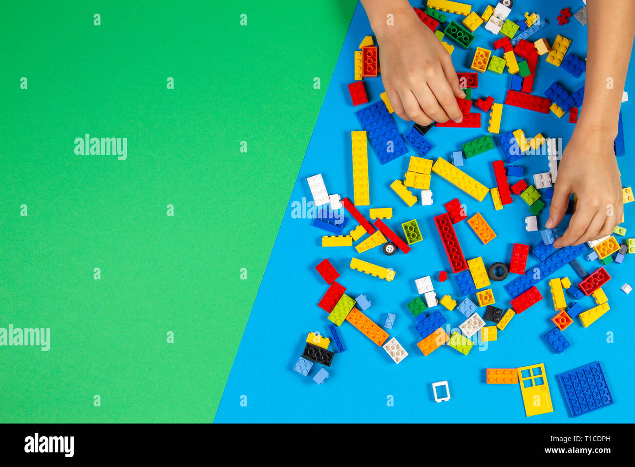 Les mains des enfants jouer avec des blocs lego colorés sur la table Banque D'Images