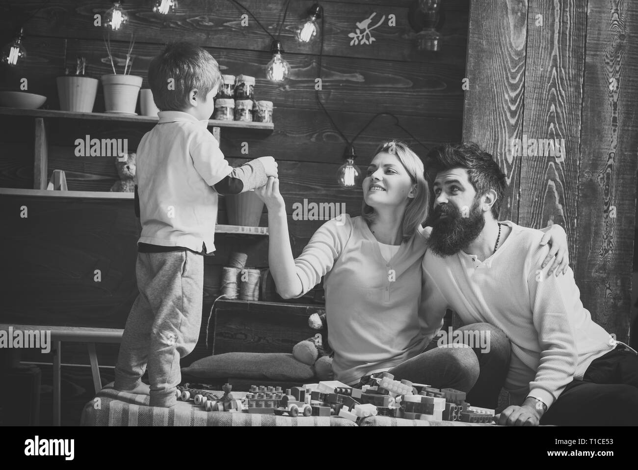 Famille heureuse de jouer avec à la maison constructeur. Mère et père à la recherche d'émotion à leur petit garçon mignon. Banque D'Images