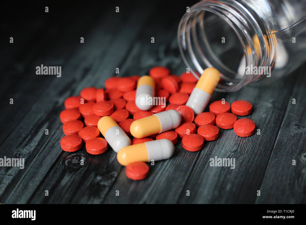 Bouteille avec des comprimés et gélules sur table en bois sombre. Concept de médicaments, antibiotiques, vitamines, pharmacie, traitement du rhume et de la grippe Banque D'Images