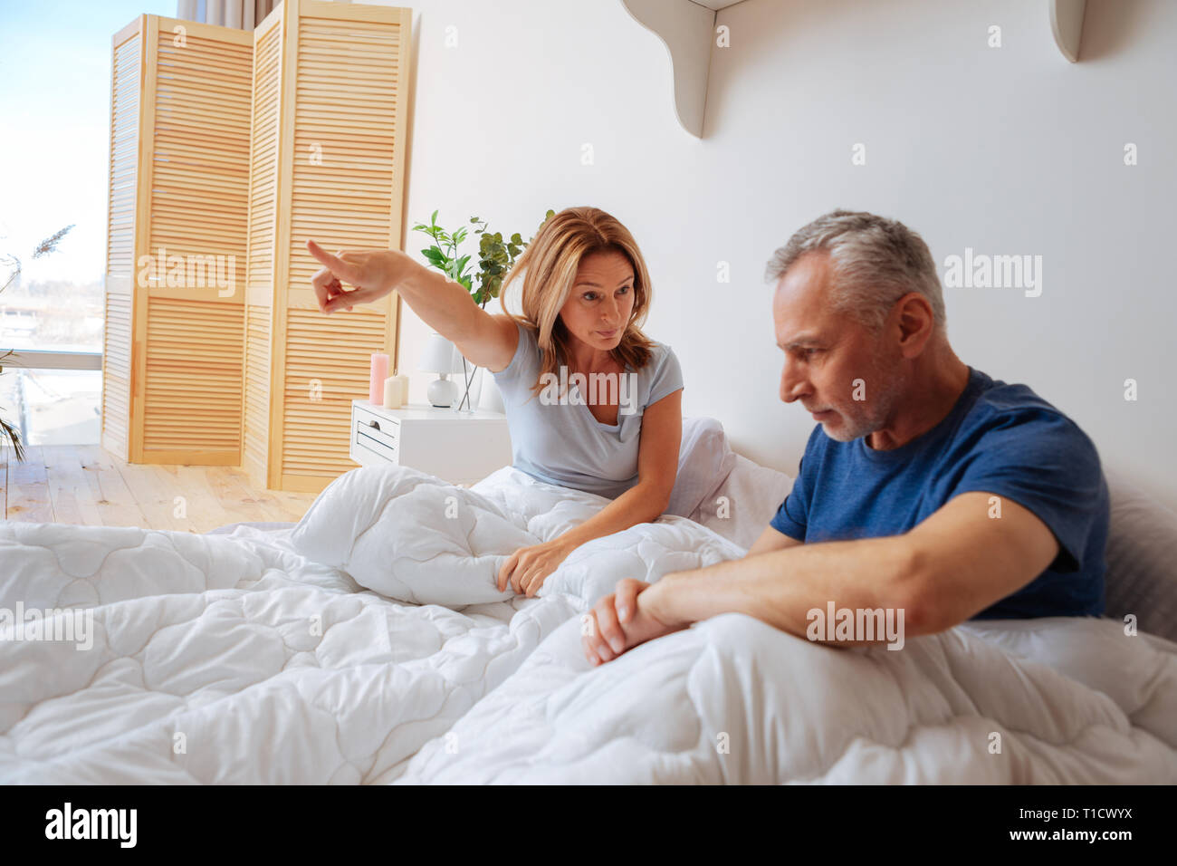 Épouse en colère demande à son mari de s'en aller de la chambre à coucher Banque D'Images