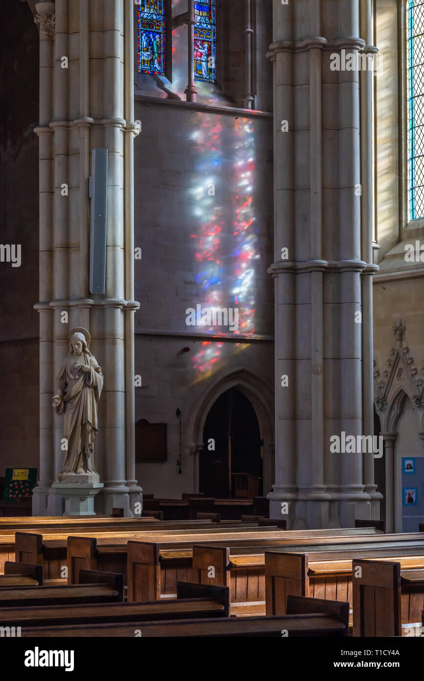 La réflexion de la lumière colorée sur un mur à partir d'une fenêtre à l'intérieur en verre teinté Arundel Cathedral, Arundel, West Sussex, England, UK Banque D'Images