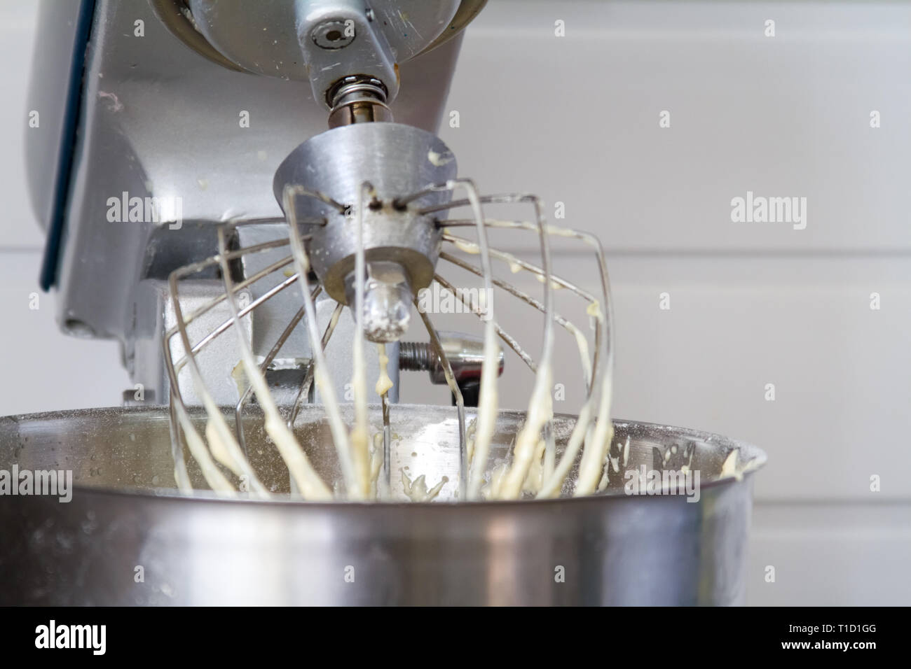 Gros plan du mixeur électrique avec de la pâte lisse de gâteau. La pâte  d'être fouetté. Mélanger la pâte blanche dans un bol mixeur avec le moteur,  la cuisson des gâteaux Photo