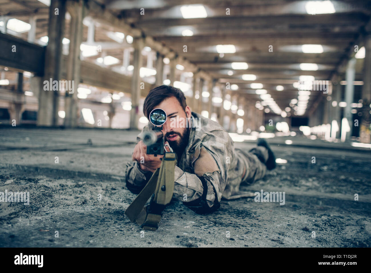 Une photo de fighter se trouvant sur le plancher à big hangar. Il est à la recherche en ligne droite à travers l'objectif et prendre aim sur appareil photo. L'homme est très grave. Il Banque D'Images