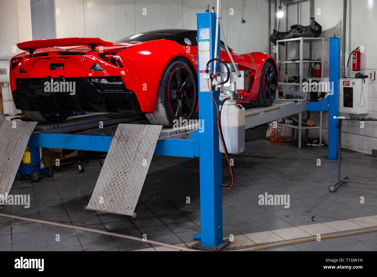 Novosibirsk, Russie - 08.01.2018 : voiture sport rouge Marussia B1 posée sur un pont dans un atelier de réparation automobile, pare-chocs arrière et becquet Banque D'Images