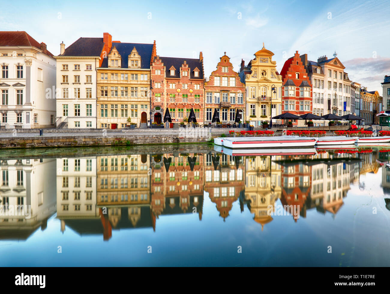 Gand, Belgique. Lever du soleil dans le centre historique de Gand avec bâtiments médiévaux de Korenlei et Graslei, château des comtes (Gravensteen) reflétant dans Banque D'Images