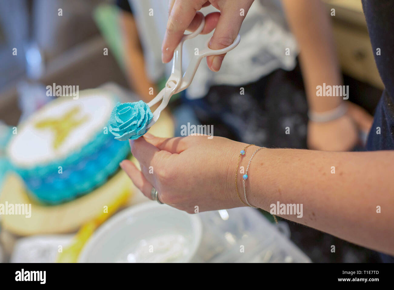Décorer un gâteau d'anniversaire avec des fleurs bleu sucre glace Banque D'Images