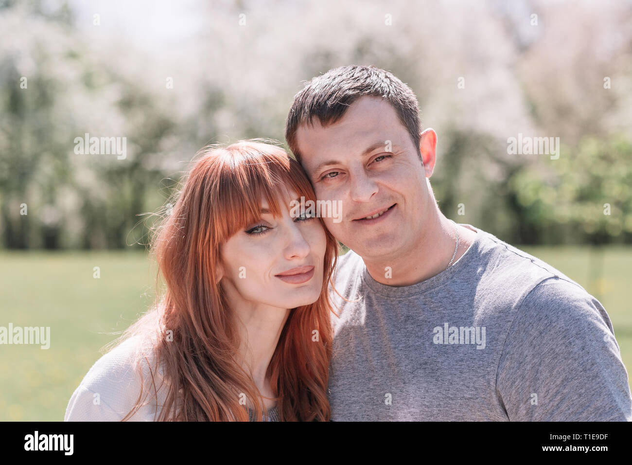 Jeune couple dans l'amour debout dans un parc au printemps Banque D'Images