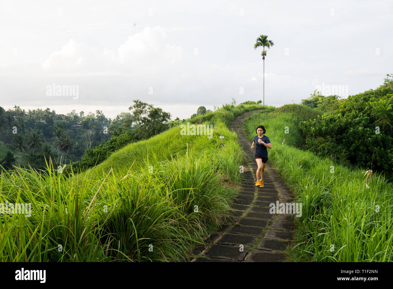 Happy girl tourne au milieu de la piste de jogging à Ubud Bali Banque D'Images