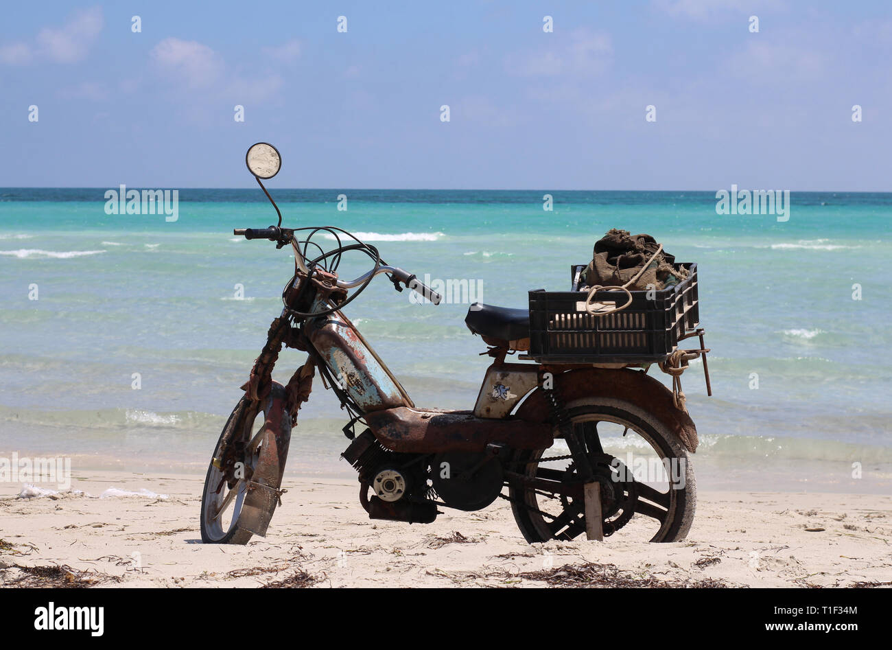 Une vieille moto est sur le sable à la plage. Près de la mer et l'eau turquoise. Soleil, l'été. Il n'est pas n'importe qui. Banque D'Images