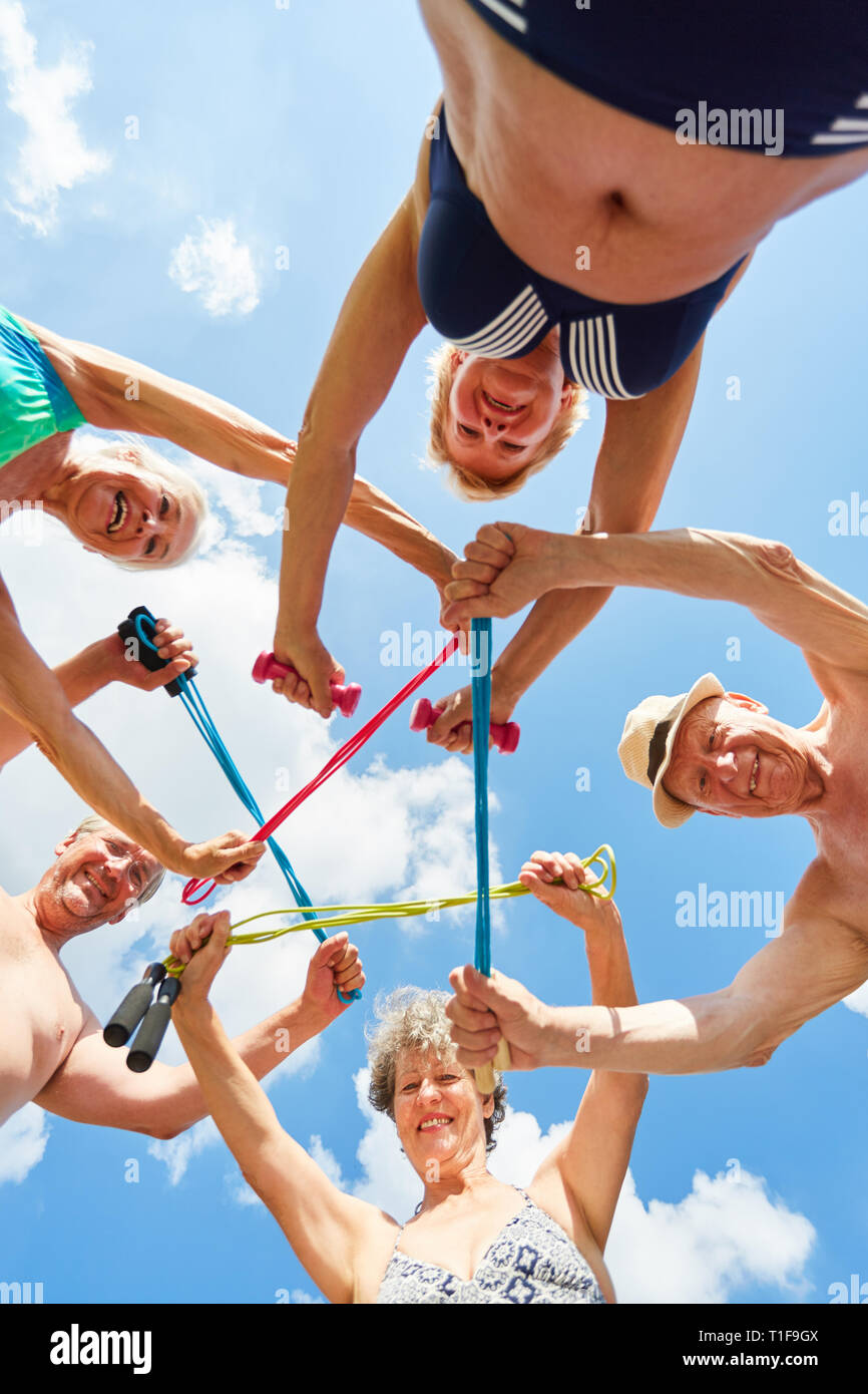 Groupe actif d'aînés avec la corde à sauter dans un cercle au centre rehab de sport Banque D'Images